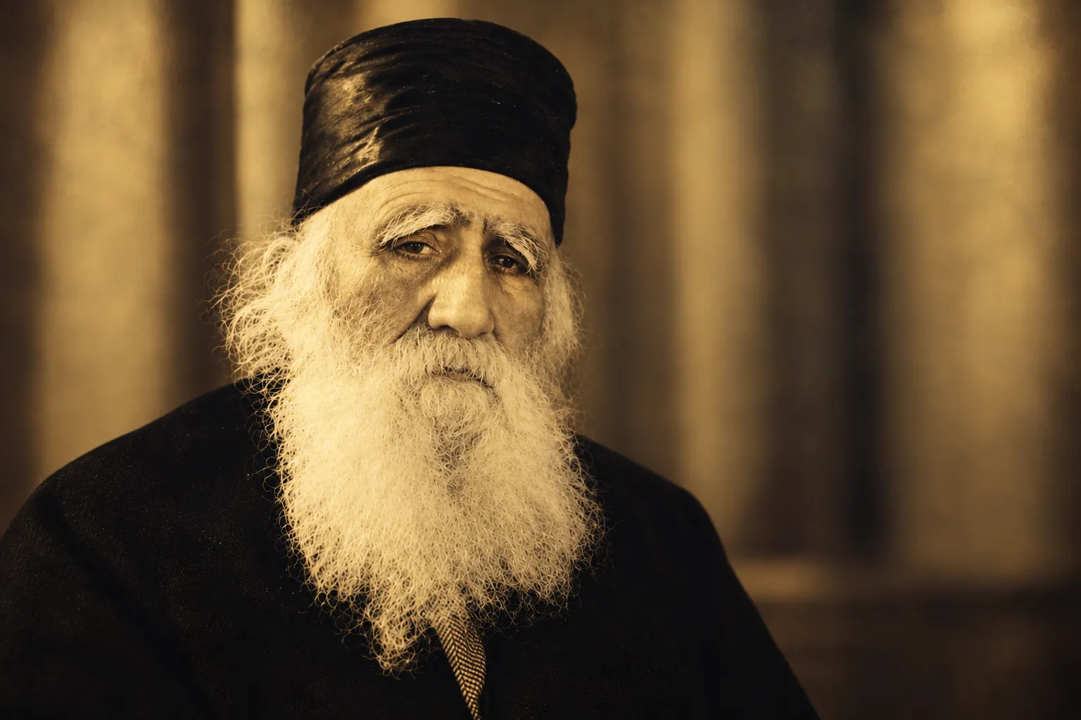 תצלום של חכם אפרים הכהן: זקן לבן ארוך, מגבעת שחורה, מבט ישיר ושקט